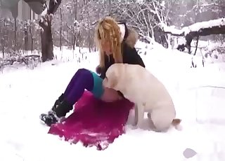 Amateur with a blond hair boning a dog in the snow